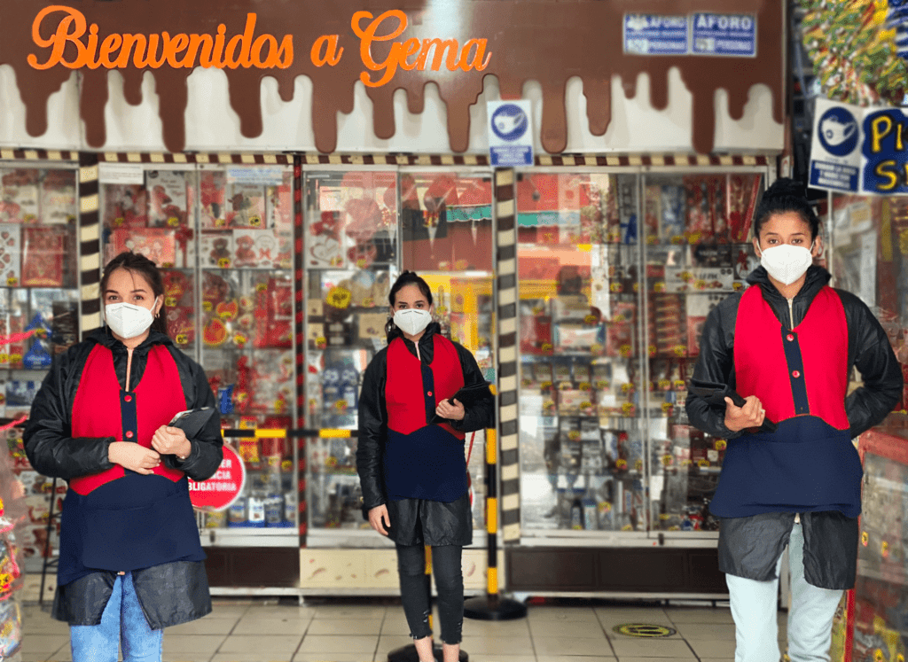 banner en la parte interior de la tienda con 3 señoritas de atencion a ventas.